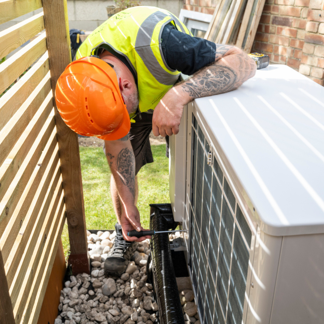 man checking a heat pump