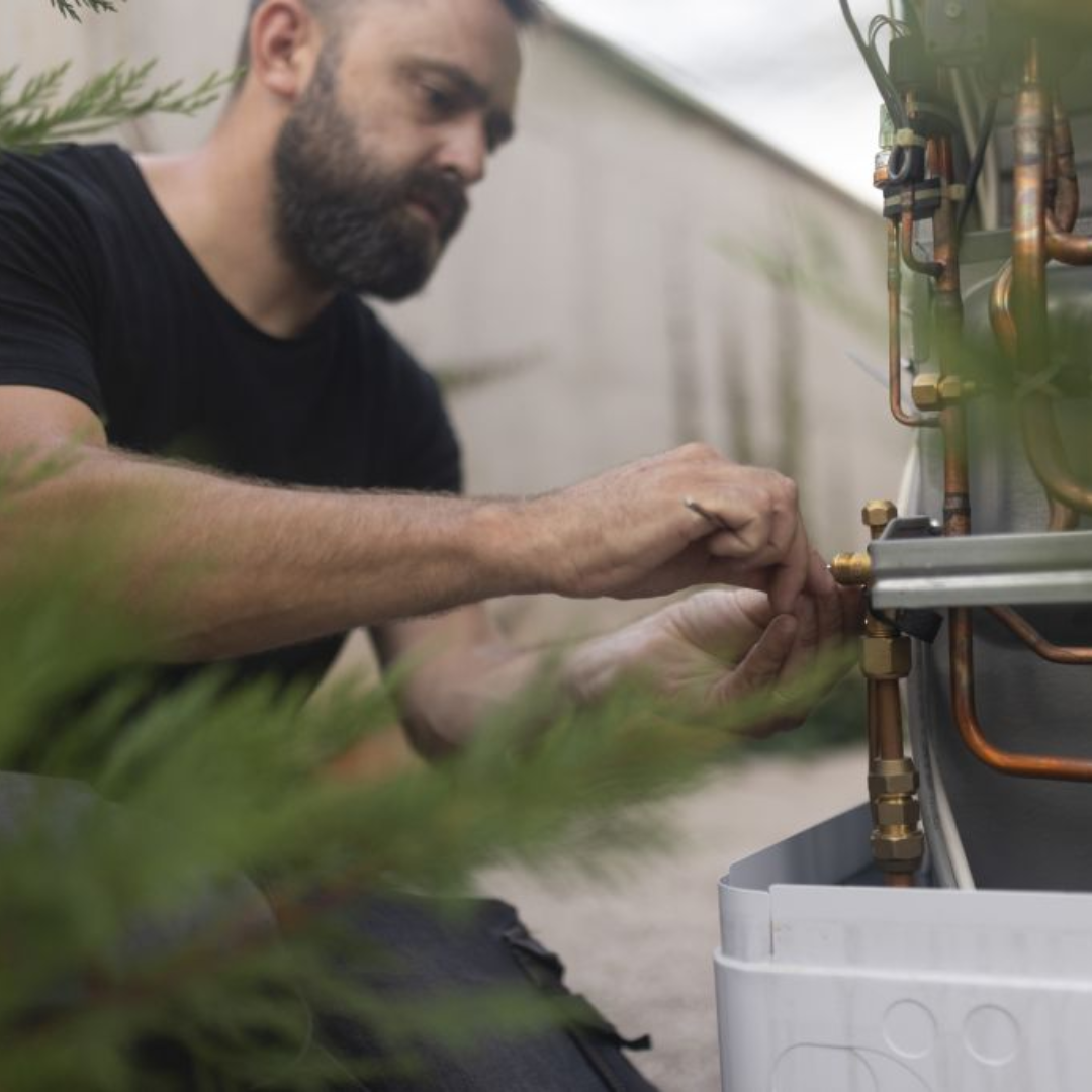 man fixing heat pump