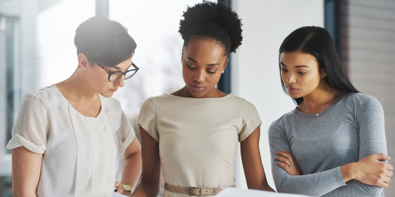 3 women looking at a report